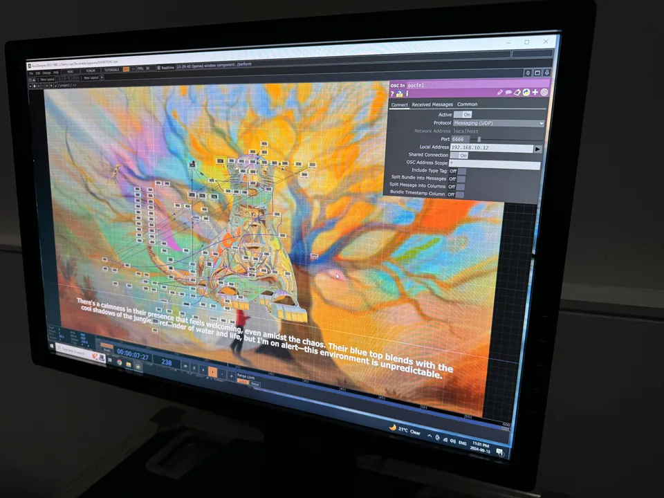 Una pantalla con TouchDesigner abierto: una red de nodos sobre un árbol pintado en naranja y azul, y una línea de la historia del jaguar.