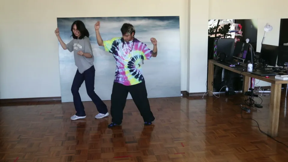 Dos bailarines sobre un piso de parquet, en una sala con un cuadro grande, en una de las primeras sesiones.