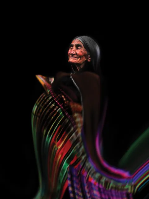 Un retrato de Las Awichas: una mujer mayor de pelo largo y canoso mira hacia arriba. Su ropa se vuelve franjas de colores vivos.