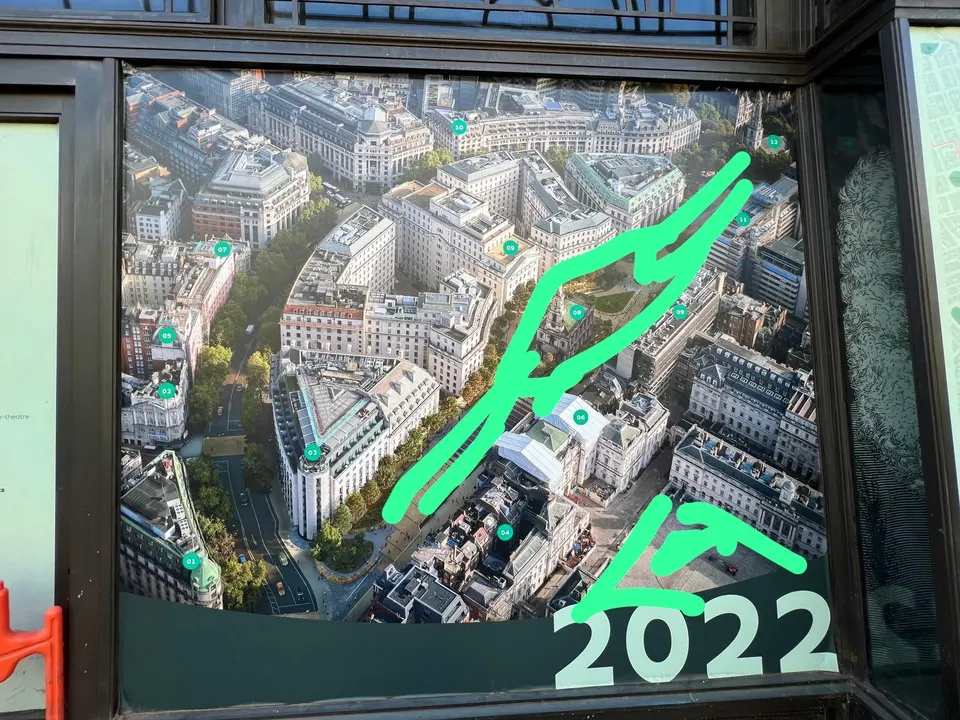 Una imagen aérea del centro de una ciudad en una vitrina, con una ruta dibujada en verde y el año 2022.